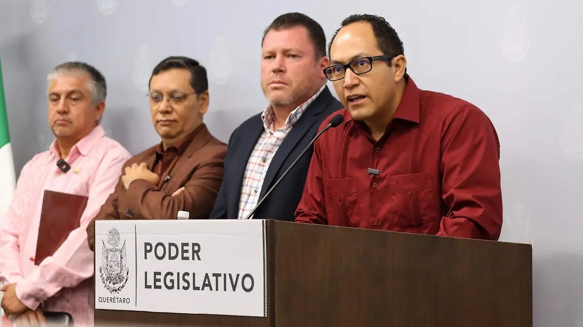 Four men standing at a podium labeled Poder Legislativo during an official press conference