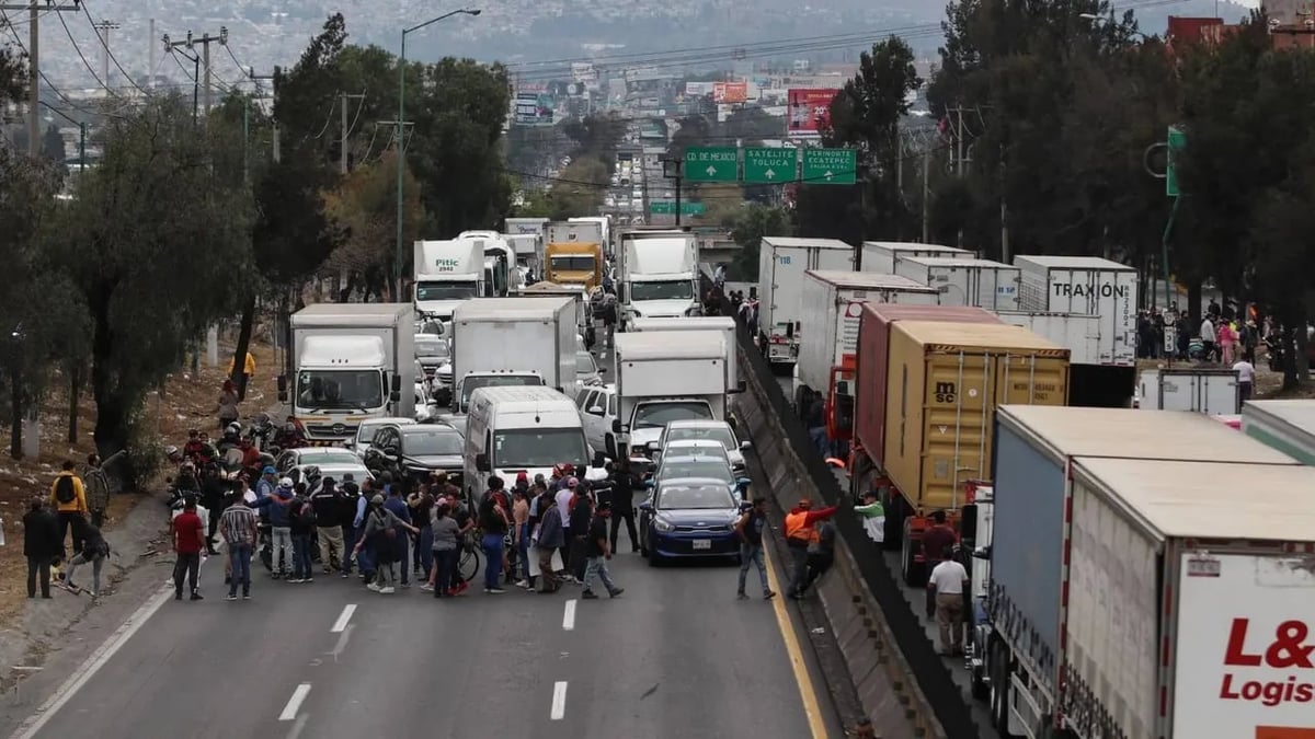 Aerial view of a highway blocked by trucks and crowds of protesters in Mexico City